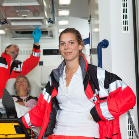Rettungswagen-Fahrerin Ausgebildete Fahrerin eines Rettungswagens vor dem RTW