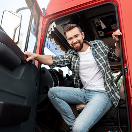 LKW Fahrer der freundlich aus der Fahrerkabine kommt