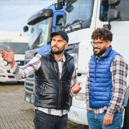 zwei-Trucker Zwei Lkw Fahrer im Gespraech auf dem Parkplatz